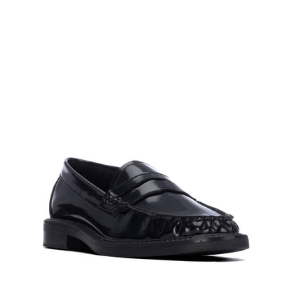 Mocassim XTI preto brilhante, vista frontal oblíqua com tira decorativa e costuras na biqueira